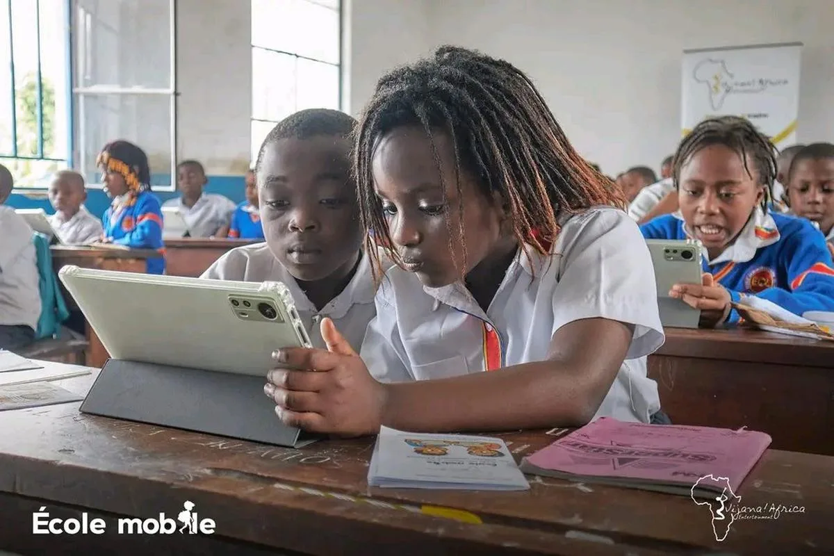 A child using a tablet during a Vijana Mobile School session in a partner classroom.
